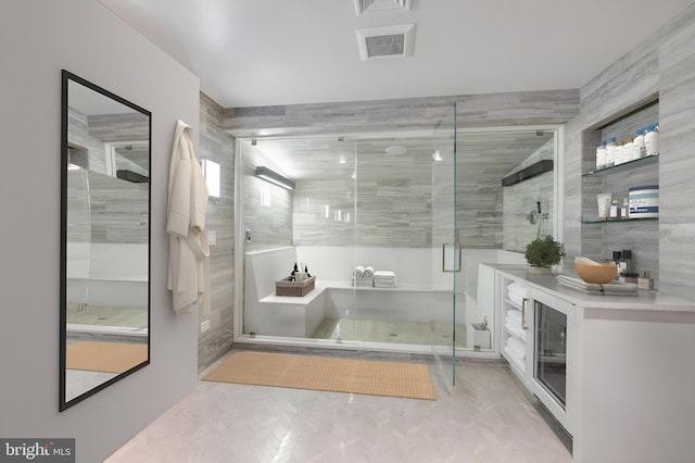 bathroom featuring tile walls and a shower with shower door