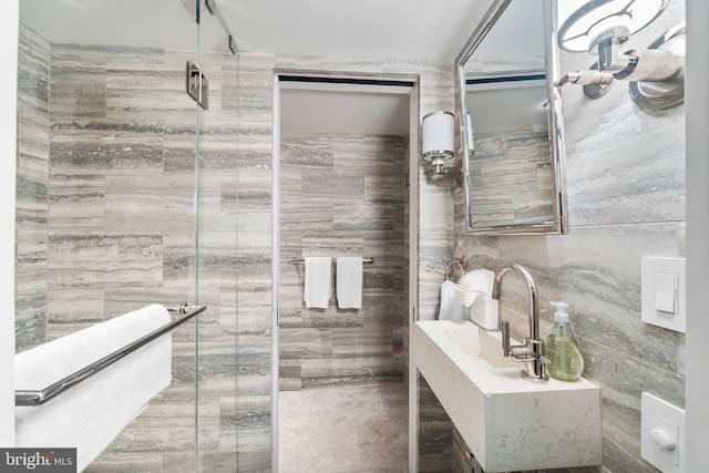 bathroom with tile walls and a shower with shower door