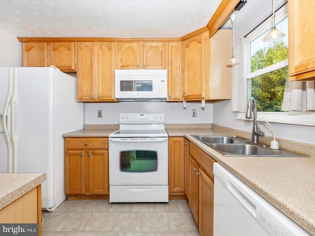 kitchen featuring white appliances, decorative light fixtures, sink, and a textured ceiling