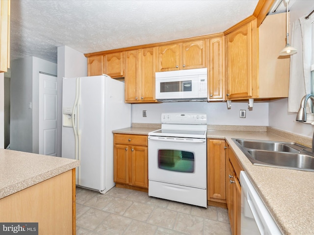 kitchen with white appliances, sink, decorative light fixtures, and a textured ceiling