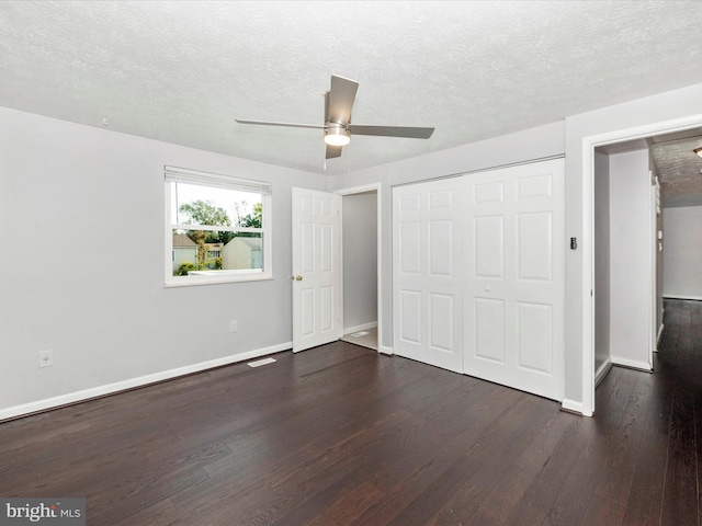 unfurnished bedroom featuring ceiling fan, dark wood-type flooring, a closet, and a textured ceiling