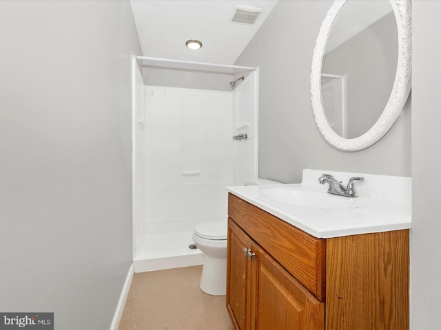 bathroom featuring walk in shower, vanity, toilet, and tile patterned floors