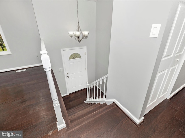 entryway with a notable chandelier and dark hardwood / wood-style flooring