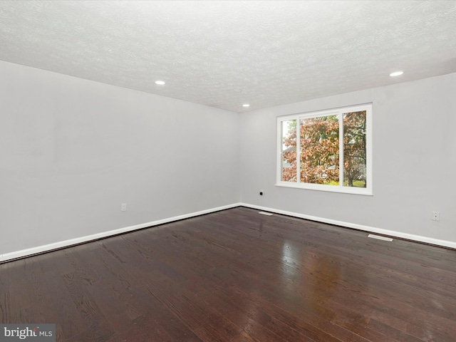 empty room featuring hardwood / wood-style flooring and a textured ceiling