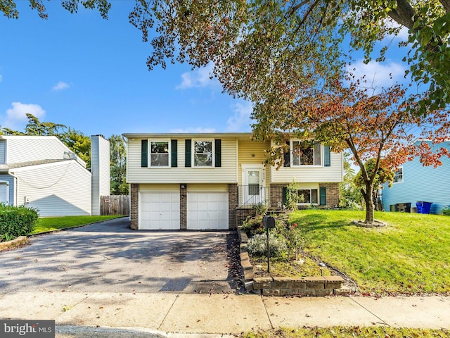 raised ranch featuring a front yard and a garage