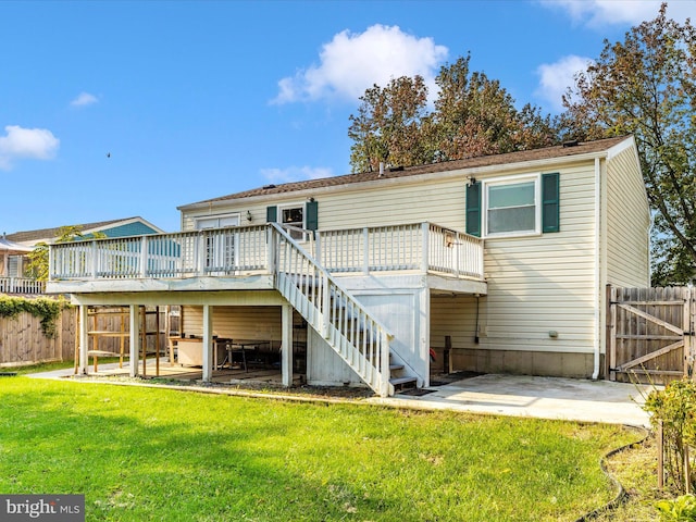 back of house with a wooden deck, a lawn, and a patio area