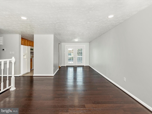 unfurnished living room featuring a textured ceiling, french doors, and dark hardwood / wood-style flooring