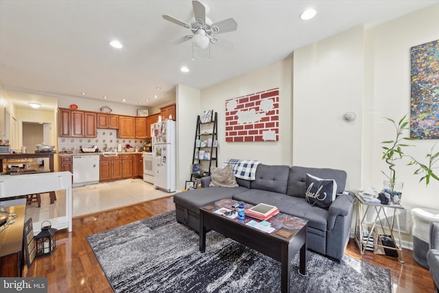 living room with ceiling fan, sink, and light hardwood / wood-style floors