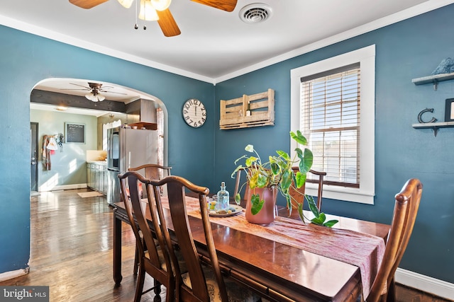 dining space featuring crown molding, wood-type flooring, and ceiling fan