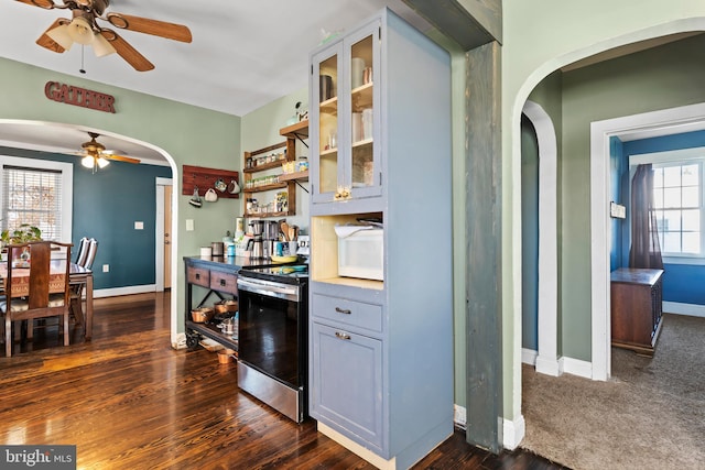 kitchen featuring stainless steel range with electric stovetop, ceiling fan, dark wood-type flooring, and a wealth of natural light