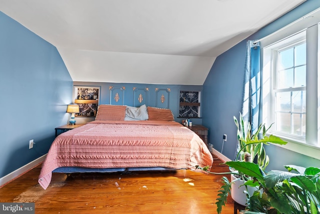 bedroom featuring lofted ceiling and hardwood / wood-style flooring