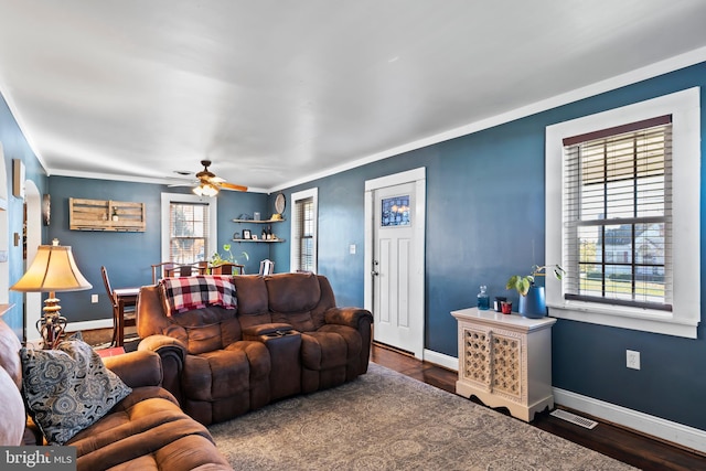 living room featuring dark wood-type flooring, crown molding, and ceiling fan