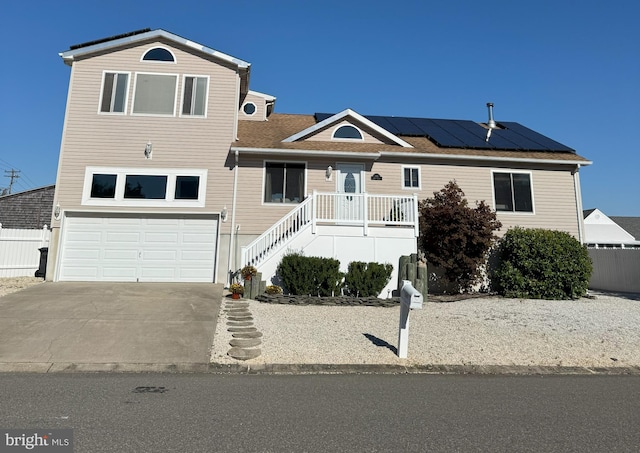 view of front facade featuring solar panels and a garage