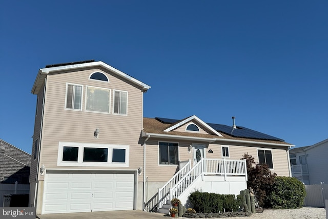 front of property featuring solar panels and a garage