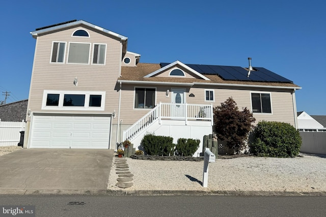 view of front of property featuring solar panels and a garage