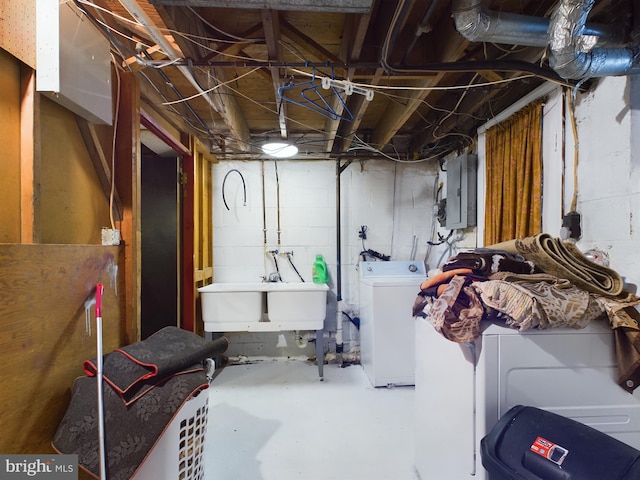 basement featuring electric panel, sink, and washing machine and dryer