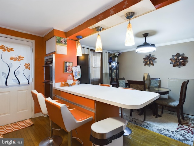 kitchen with hanging light fixtures, dark hardwood / wood-style flooring, and ornamental molding