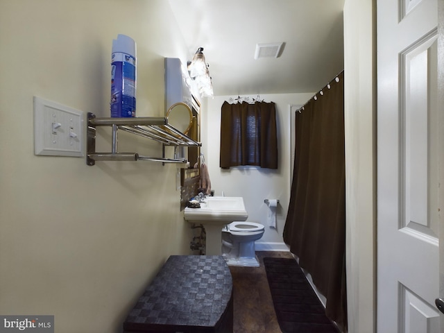 bathroom with hardwood / wood-style flooring and toilet