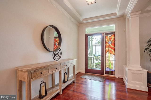 foyer entrance featuring decorative columns, crown molding, a tray ceiling, and dark hardwood / wood-style floors