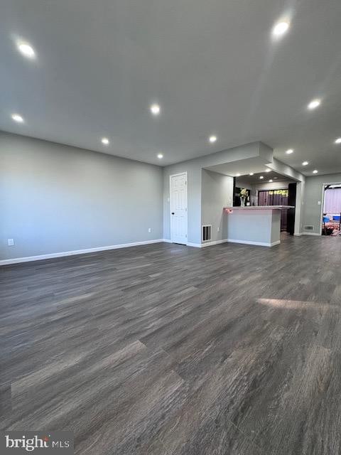 unfurnished living room with dark wood-type flooring