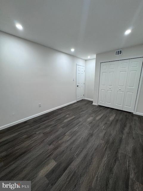 unfurnished bedroom featuring dark wood-type flooring and a closet