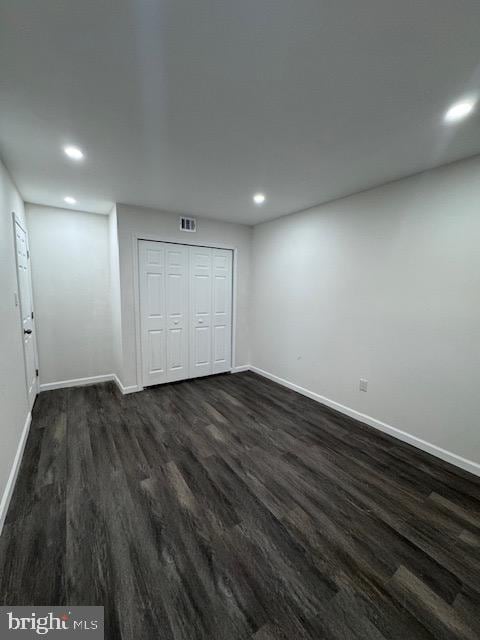 unfurnished bedroom featuring dark hardwood / wood-style floors and a closet