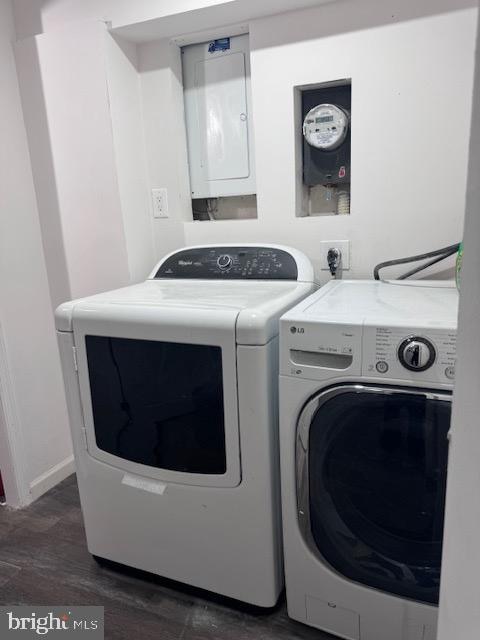 laundry room with dark hardwood / wood-style floors, electric panel, and washing machine and clothes dryer