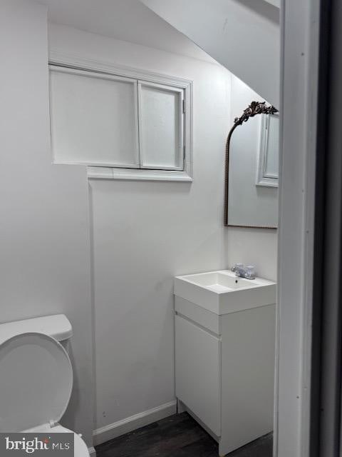 bathroom featuring vanity, toilet, and hardwood / wood-style floors