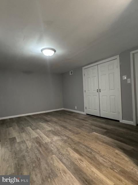 unfurnished bedroom with a closet and dark hardwood / wood-style flooring