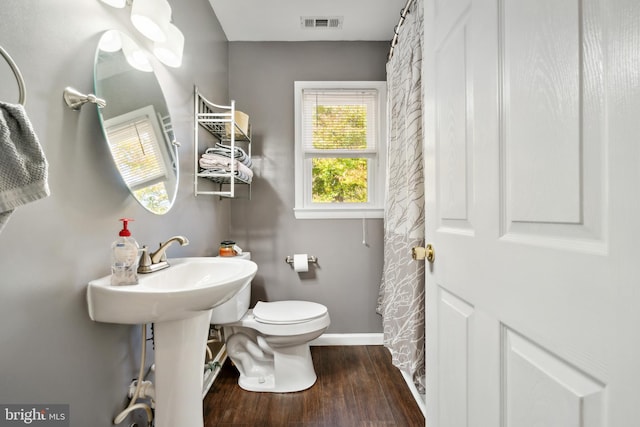 bathroom featuring wood-type flooring and toilet