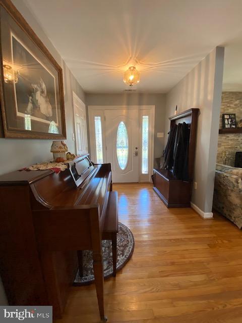 entrance foyer with light hardwood / wood-style flooring and an inviting chandelier