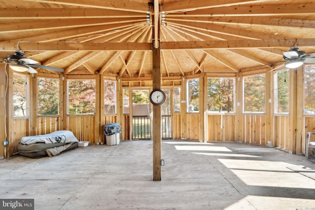 unfurnished sunroom featuring lofted ceiling, a healthy amount of sunlight, and ceiling fan