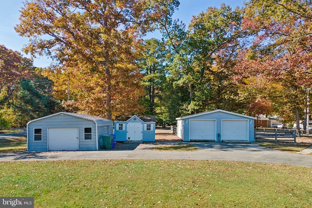 view of front of property featuring a storage unit, a front lawn, and a garage