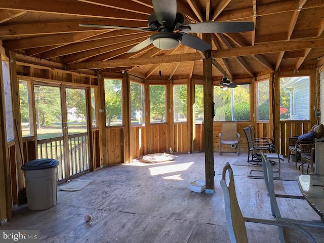 unfurnished sunroom featuring vaulted ceiling and a wealth of natural light