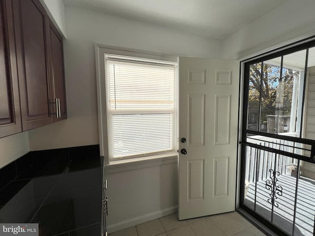 doorway to outside with light tile patterned flooring