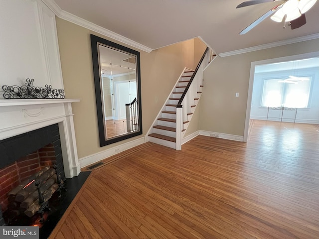 living room featuring ceiling fan, wood-type flooring, and crown molding