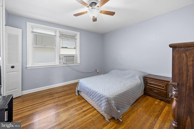 bedroom with cooling unit, dark wood-type flooring, and ceiling fan