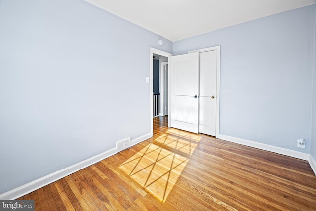 unfurnished bedroom featuring a closet and hardwood / wood-style floors