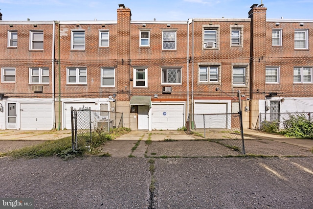 view of property featuring a garage and cooling unit