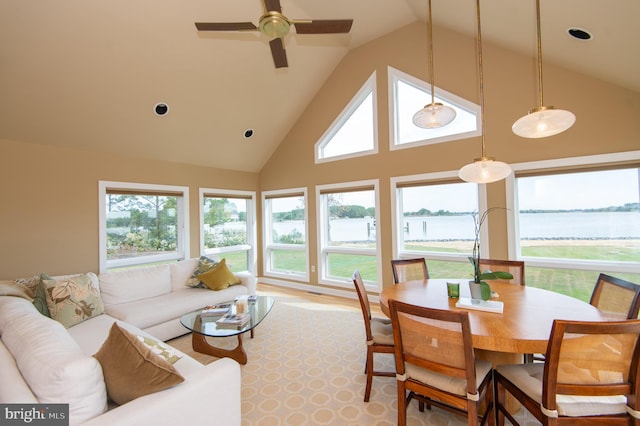 interior space with a water view, light hardwood / wood-style floors, high vaulted ceiling, and ceiling fan