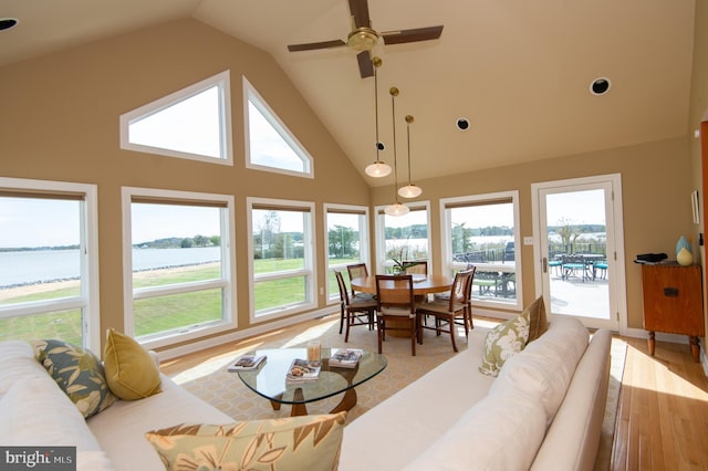 sunroom with a water view, vaulted ceiling, and ceiling fan