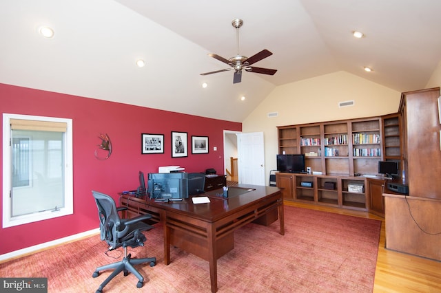 home office featuring light hardwood / wood-style floors, vaulted ceiling, and ceiling fan