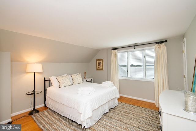 bedroom featuring lofted ceiling and light hardwood / wood-style flooring