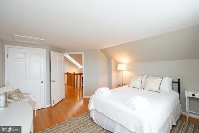 bedroom featuring hardwood / wood-style flooring and vaulted ceiling