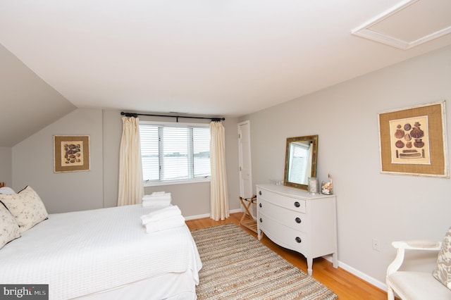 bedroom featuring light wood-type flooring and lofted ceiling