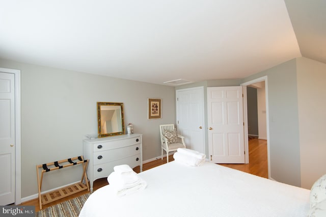 bedroom with light hardwood / wood-style flooring and lofted ceiling