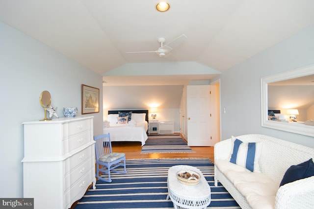 bedroom with ceiling fan, hardwood / wood-style flooring, and vaulted ceiling