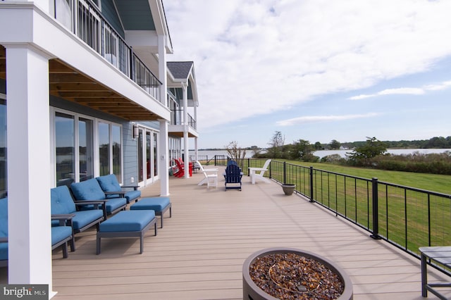 deck featuring a yard and an outdoor living space with a fire pit