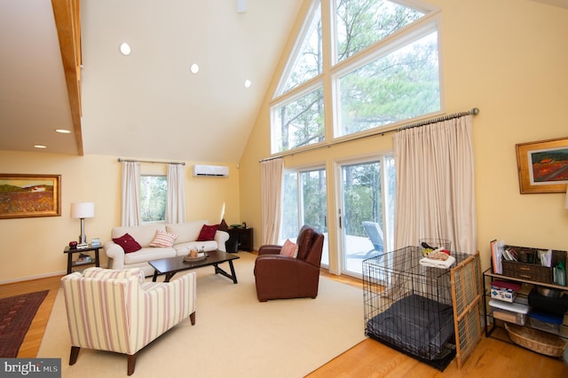 living room with light hardwood / wood-style floors, high vaulted ceiling, and a healthy amount of sunlight