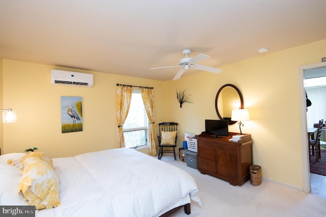 bedroom with ceiling fan, light carpet, and a wall unit AC